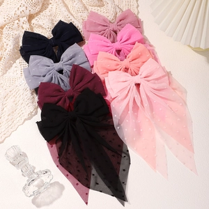 Detail of multi-color polka dot mesh hair bows with long ribbons in elegant flat lay