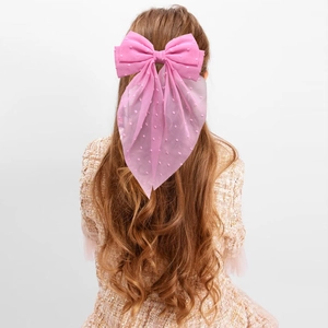 Pink polka dot tulle hair bow clip with long streamers on child's hair, sweet style
