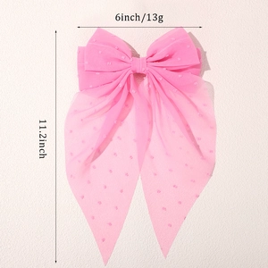 Detail view of pink large mesh hair bow with plumeti dots and long flowing ribbons