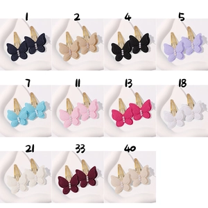 Flat lay of colorful butterfly hair clips with embroidery and triple pearl details
