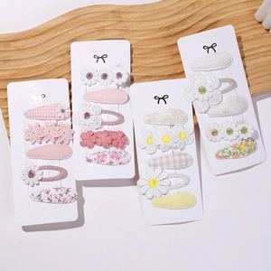 Detailed macro view of embroidered daisy and floral lace hair clip set for girls