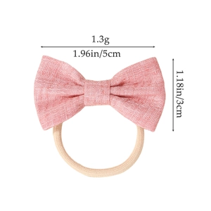 Pink bow hair tie for baby girls made of woven fabric with elastic nylon band