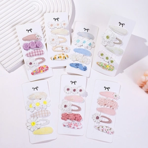 Détail de 7 sets de barrettes marguerite avec motifs floraux et à carreaux