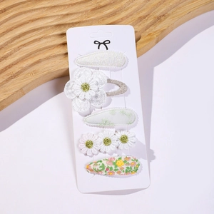 Close-up of 5-piece daisy and lace snap hair clips set in white and light green hues