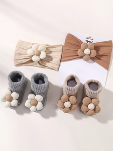 Detailansicht von Baby-Stirnband und Socken mit 3D-Blumenakzenten aus weicher Baumwolle