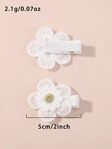 Detailed macro view of white daisy hair clip with lace embroidery and gold thread center