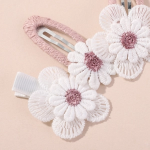 Detailed close-up of pink fabric BB clip and white embroidered floral hair pins set