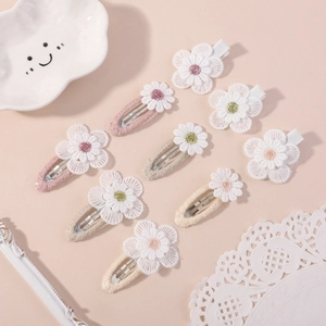 Close-up of nine handmade fabric flower hair clips with embroidered daisy details