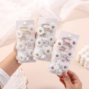 Close-up of handmade lace flower embroidery hair clips in cream and pink tones