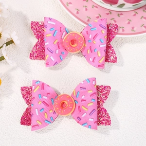 Detail of glitter bow hair clips with pink donuts and sprinkles pattern for girls