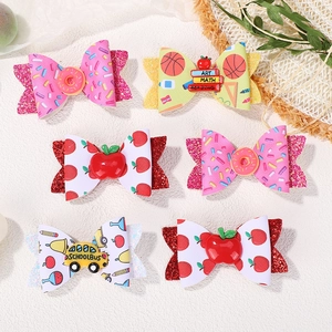Detail of 6-piece kids glitter hair clips with donut, school bus and apple patterns