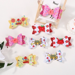 Detailed set of seven children's hair bows with donuts and school themes on a white surface