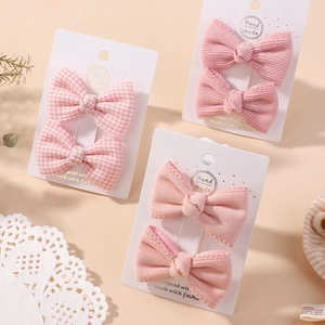 Set di fermagli per capelli rosa a quadretti e pizzo per bambine su sfondo caldo
