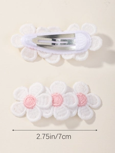 Detailed view of two white floral fabric hair clips with dimensions 2.75 inches long