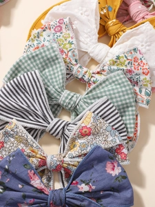 Vue à plat de nœuds en coton fleuri et barrettes en lin rayé pour les enfants