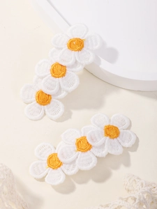 Detail of embroidered white daisy hair clips with yellow centers for girls in set of two