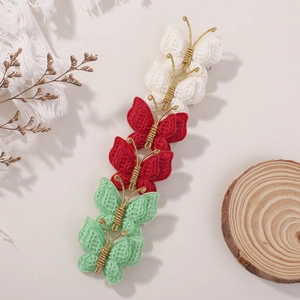 Détail des barrettes papillon faites à la main avec broderie et fil doré tressé