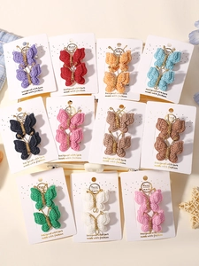 Vue macro des barrettes papillon tricotées main montrant la texture fine et les détails