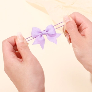 Dettaglio che mostra la forte elasticità e l'estensione dell'elastico per capelli viola