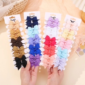 Set di fermagli per capelli con fiocchi in grosgrain per bambine su carte bianche