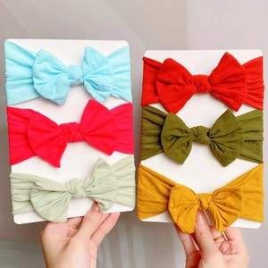 Detailed set of six colorful soft nylon baby headbands with large bows on display card
