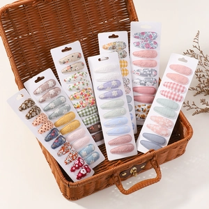 Close-up of floral fabric hair clip set featuring lace and embroidery in a vintage suitcase