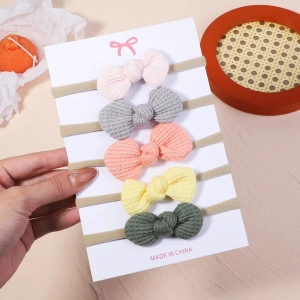Detailed view of five colorful waffle knit baby headbands with elastic nylon bands on a card
