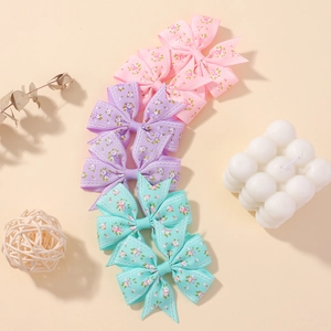 Détail de lot de six barrettes à nœuds fleuris en rose et vert menthe pour fille