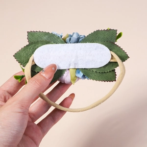 Detail of floral baby headband featuring fabric flowers and a soft elastic nylon band