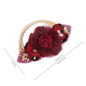 Detail of baby floral headband with burgundy chiffon flowers and golden berry accents