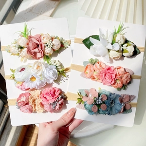 Detailed view of six floral baby headbands with delicate silk petals and pearls