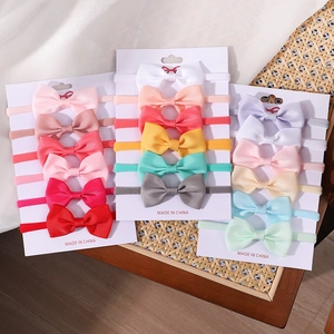 Macro view of stretchy nylon baby headbands with ribbed grosgrain bow on display cards