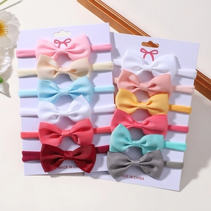 Close-up of 12-piece baby bow headband set with elastic nylon bands and ribbed textures