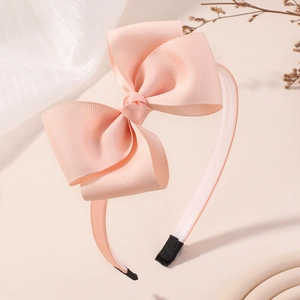 Détail d'un serre-tête rose à double nœud en polyester avec ruban gros-grain texturé