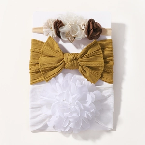 Détail de trois bandeaux pour bébé en nylon souple avec fleurs et nœuds sur une carte