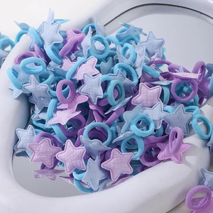 Détail d'élastiques à cheveux en forme d'étoile violets et bleus sur plateau cœur