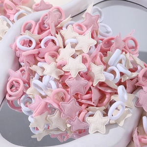 Détail d'élastiques à cheveux roses, blancs et beige avec étoiles en tissu pour filles