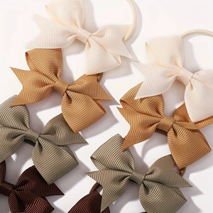 Macro detail of grosgrain ribbon bow hair ties showing high-quality woven texture