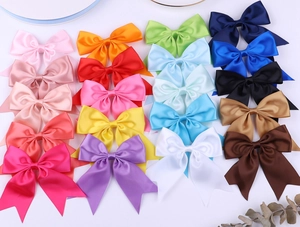 Flat lay of colorful satin hair bows in 16 vibrant colors with elegant long fishtail ribbons