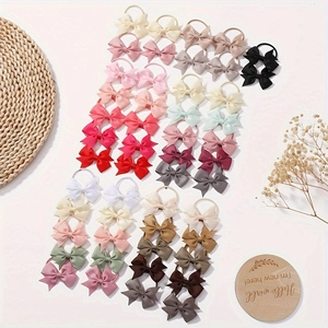 Close-up of baby girl bow hair ties set in various colors including pink and blue