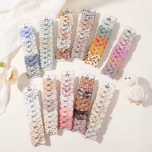 Flat lay of colorful plaid and floral bow hair clips set for girls on display cards