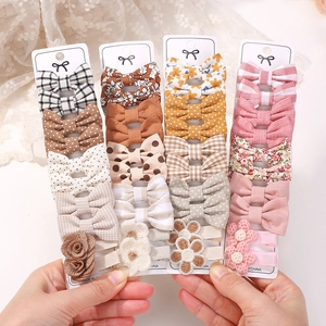 Detailed view of 20-piece girls' hair clip set featuring fabric bows and floral patterns
