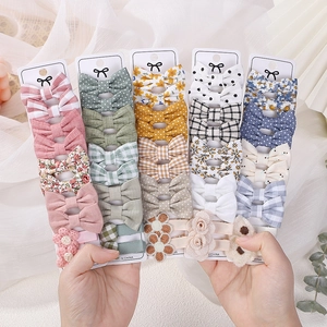 Close-up of assorted fabric bow hair clips with floral, plaid, and polka dot patterns