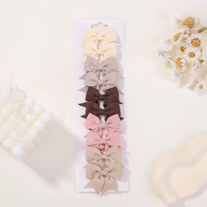 Detailed set of 10 ribbon bow hair clips in earthy tones on a white display card