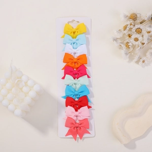 Detailed set of ten colorful grosgrain ribbon bow hair clips on a white display card