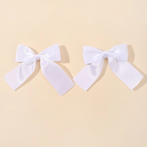 Detail of white satin bow hair clips set with silky flowing ribbons for girls