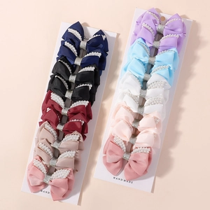 Detail of 10-piece bow hair clips set with pearls and glitter centers on display cards