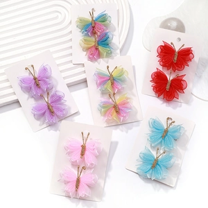 Détail de pinces à cheveux papillon en tulle coloré avec dégradés et corps en fil doré