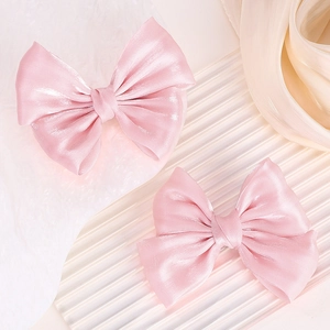 Detalle de pinzas para el pelo de satén rosa con elegante acabado brillante y suave