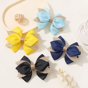 Detailed close-up of handmade bow hair clips with blue glitter accents and ribbed texture